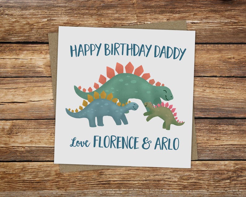 May include: A square greeting card with a watercolor illustration of three dinosaurs. The card reads "HAPPY BIRTHDAY DADDY" above the dinosaurs and "Love FLORENCE & ARLO" below. The card is on a brown envelope.