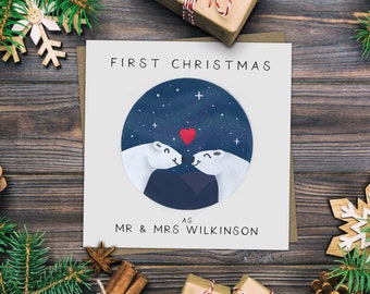 May include: A white card with the text "First Christmas as Mr & Mrs Wilkinson" and a circle illustration of two polar bears kissing under a starry night sky.