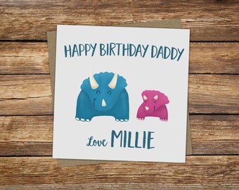 May include: A white card with a blue and pink dinosaur illustration. The card reads "Happy Birthday Daddy" and "Love Millie".