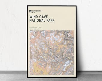 May include: A framed poster featuring a topographic map of Wind Cave National Park in South Dakota. The poster has a black frame and includes the park's name and elevation details. The map uses a palette of beige, peach, gray, and yellow.