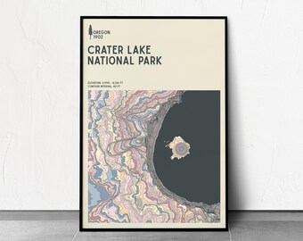 May include: A framed poster featuring a topographic map of Crater Lake National Park in Oregon. The poster includes the text "Crater Lake National Park" and elevation details. The map uses a color palette of blues, pinks, and yellows.