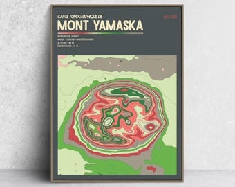 May include: A framed topographic map print of Mont Yamaska, Quebec, featuring a dark gray background with cream text. The map displays colorful contour lines in shades of red, green, and beige, with printed details including altitude 411 m.