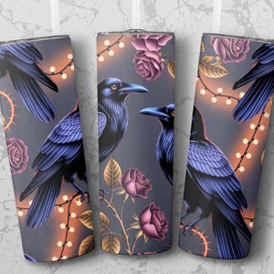 Puede incluir: Juego de tres vasos de acero inoxidable con fondo gris oscuro. Cada vaso presenta un diseño de cuervos negros, rosas rosas y luces de cadena. Los cuervos tienen plumas azules y están posados en ramas.