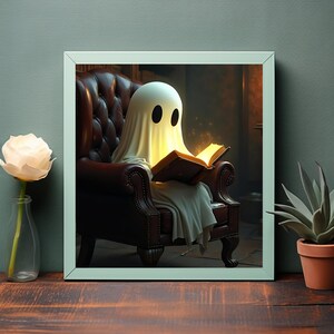 Könnte beinhalten: Ein gerahmter Druck, der einen Cartoon-Geist zeigt, der in einem braunen Ledersessel ein Buch liest. Der Geist ist mit einem weißen Laken mit schwarzen Augenlöchern bedeckt. Das Buch strahlt ein warmes Licht aus, das auf ein magisches oder Fantasy-Thema hindeutet.