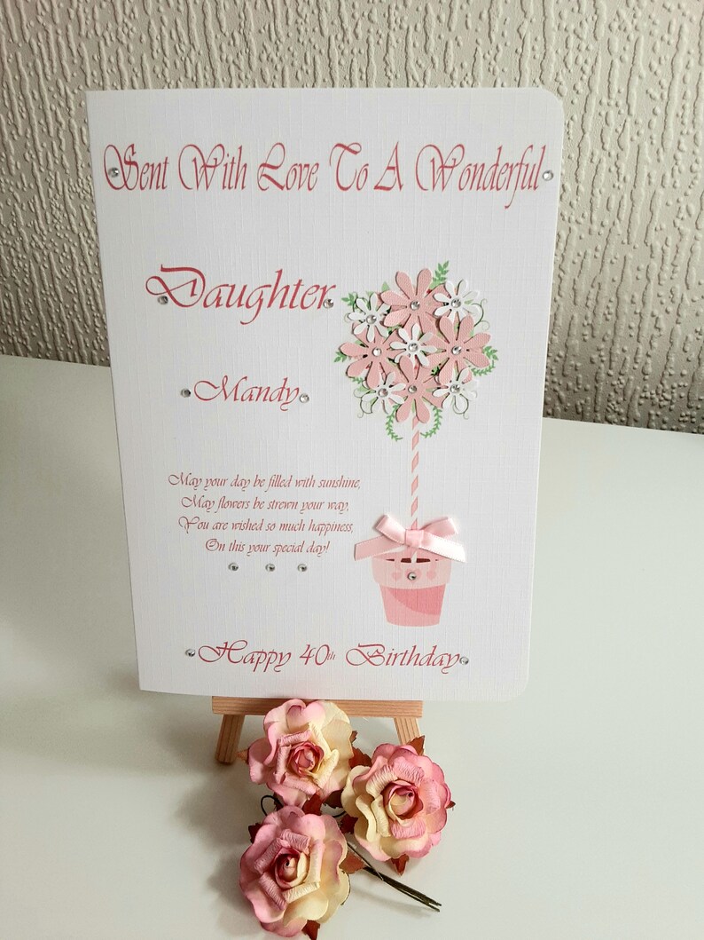 May include: A pink and white birthday card with a flower bouquet design and the text "Sent With Love To A Wonderful Daughter Mandy. May your day be filled with sunshine, May flowers be strewn your way You are wished so much happiness, On this your special day! Happy 40th Birthday."