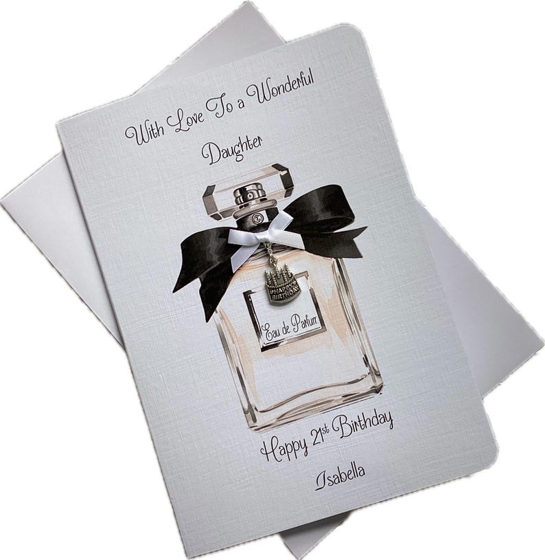 May include: A light gray birthday card with a perfume bottle illustration. The bottle has a black bow and a silver charm. Text reads "With Love To a Wonderful Daughter", "Happy 21st Birthday", and "Isabella".