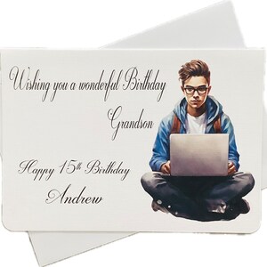 May include: A birthday card with the text "Wishing you a wonderful Birthday Grandson Happy 15th Birthday Andrew." The card features an illustration of a young person wearing glasses and a blue hoodie, sitting with a laptop. The card is white with a white envelope.