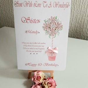 May include: A pink and white birthday card with a cupcake and flowers. The card says "Sent With Love To A Wonderful Sister Mandy" and "Happy 40th Birthday".