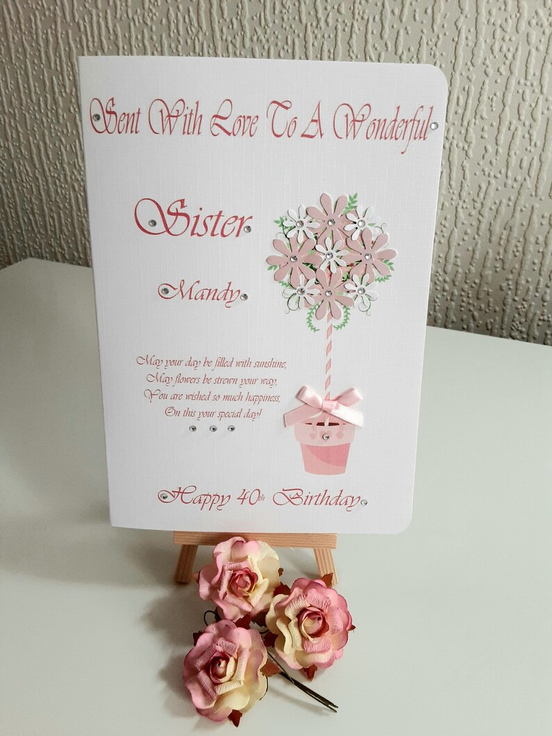 May include: A pink and white birthday card with a cupcake and flowers. The card says "Sent With Love To A Wonderful Sister Mandy" and "Happy 40th Birthday".