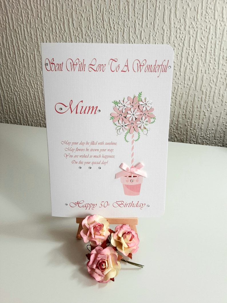 May include: A pink and white card with a flower bouquet design and the text "Sent With Love To A Wonderful Mum. May your day be filled with sunshine, May flowers be strewn your way, You are wished so much happiness, On this your special day! Happy 50th Birthday."