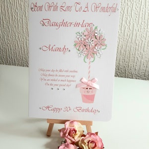 May include: A pink and white handmade card with a flower bouquet design and the text "Sent With Love To A Wonderful Daughter-in-law Mandy Happy 30th Birthday."