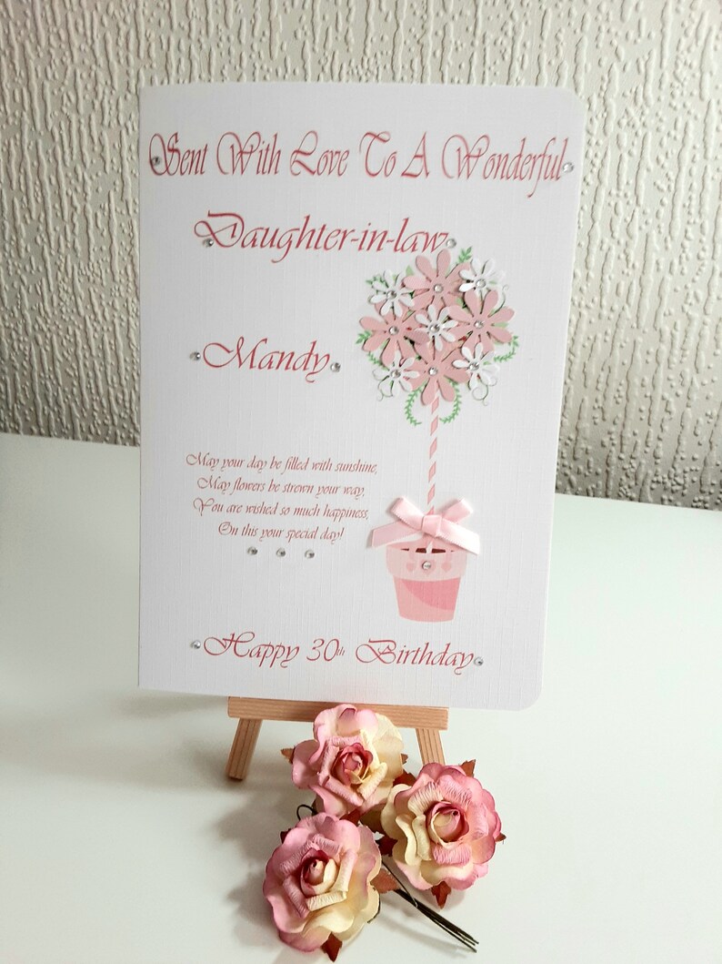 May include: A pink and white handmade card with a flower bouquet design and the text "Sent With Love To A Wonderful Daughter-in-law Mandy Happy 30th Birthday."
