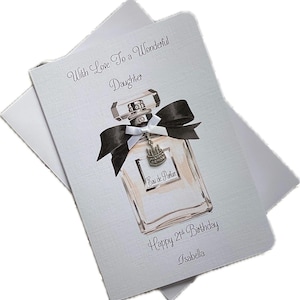 May include: A birthday card for a daughter, featuring a perfume bottle illustration with a black bow and a charm. The card reads "With Love To a Wonderful Daughter" and "Happy 21st Birthday, Isabella."
