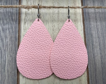 May include: A pair of pink leather teardrop earrings with silver hooks.