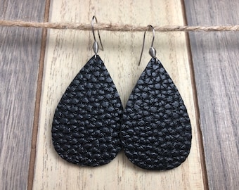 May include: A pair of black leather teardrop earrings with silver hooks.