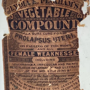May include: Vintage bottle with a label for Lydia E. Pinkham's Vegetable Compound. The brown and black label details the product's uses, including for "Female Weaknesses." The bottle is made of clear glass.