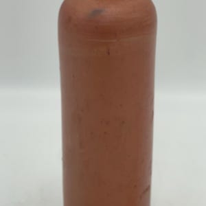 May include: A terracotta brown ceramic bottle with a rounded bottom and a slightly flared top. The bottle is approximately 10 inches tall.