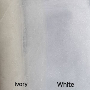 May include: Two swatches of tulle fabric, one ivory and one white, both with a subtle sparkle finish. The fabric is sheer and lightweight.