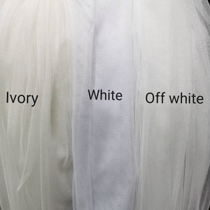 Puede incluir: Primer plano de tres muestras de tejido de tul en marfil, blanco y blanco roto.