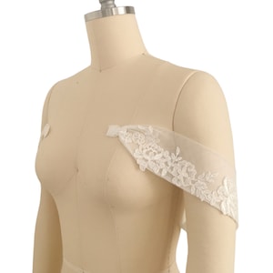 Puede incluir: Tirantes de hombro de novia de encaje blanco con bordado floral. Los tirantes son de tela transparente y est&aacute;n dise&ntilde;ados para usarse sobre un vestido de novia.
