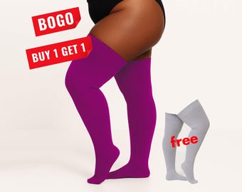 May include: A pair of vibrant magenta ribbed over-the-knee socks worn on the legs, accompanied by a separate pair of light gray ribbed over-the-knee socks. Red text overlays state BOGO, BUY 1 GET 1, and free, indicating a promotional offer.
