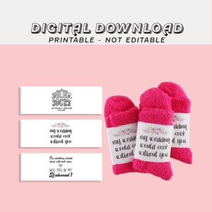 May include: Three pink fluffy socks with white floral trim and labels that say "My wedding would sook without you" and "Bride Crew Socks".