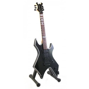 May include: Black electric guitar with a star-shaped body and a black and white finish. The guitar has a black headstock with a white "HATE" logo. The guitar is on a black stand.