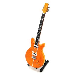 May include: A vintage-style electric guitar with a natural wood finish and a black pickguard. The guitar has a single cutaway body and a set of six tuning keys at the headstock.