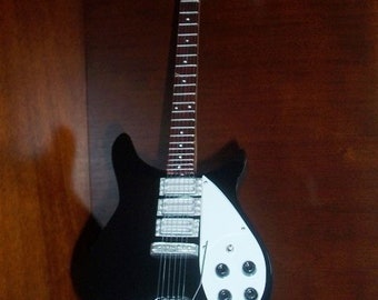 Mini guitarra de John Lennon de los Beatles, artículo de colección con soporte incluido.