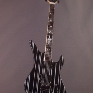 May include: Black electric guitar with white stripes, a black headstock, and silver tuning pegs.