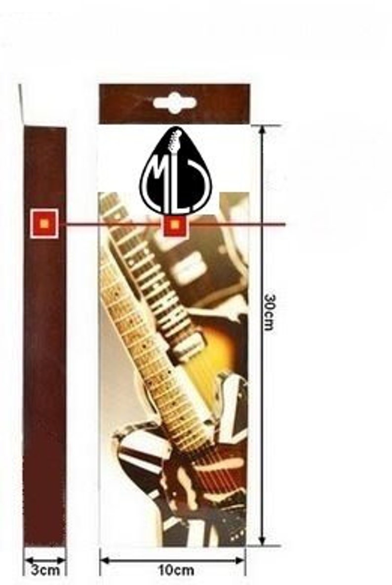 Puede incluir: Una correa de guitarra marr&oacute;n con un dise&ntilde;o de guitarra en blanco y negro. La correa mide 3 cm de ancho y 30 cm de largo. La correa tiene un logotipo que dice "ML".