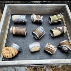 May include: A drawer filled with nine different leather and metal bracelets. The bracelets are all different colors and designs, and they are arranged in a neat row.