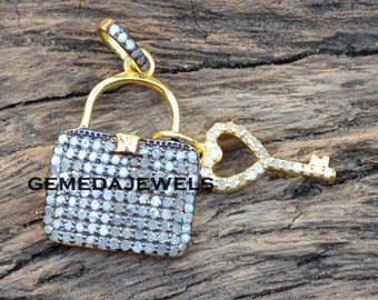 May include: A gold pendant in the shape of a lock and key, both covered in small white diamonds. The key has a heart-shaped bow.