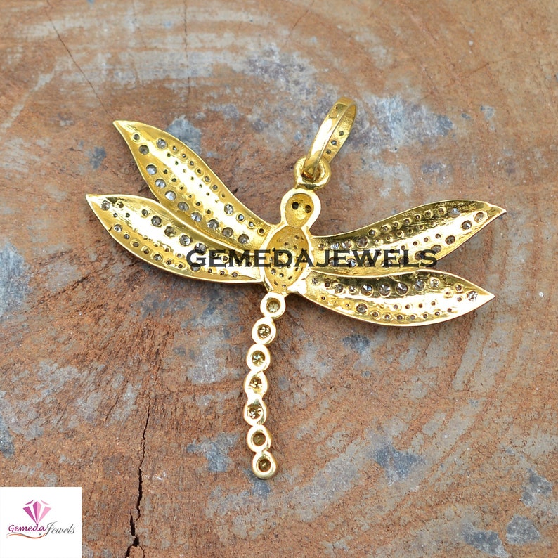 Peut inclure: Pendentif en forme de libellule en or avec des pierres transparentes. Les ailes de la libellule sont recouvertes de petites pierres et le corps est une seule pierre. Le pendentif a une boucle en haut pour l'attacher &agrave; une cha&icirc;ne.