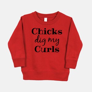Puede incluir: Sudadera roja con texto negro que dice "Chicks dig my Curls".