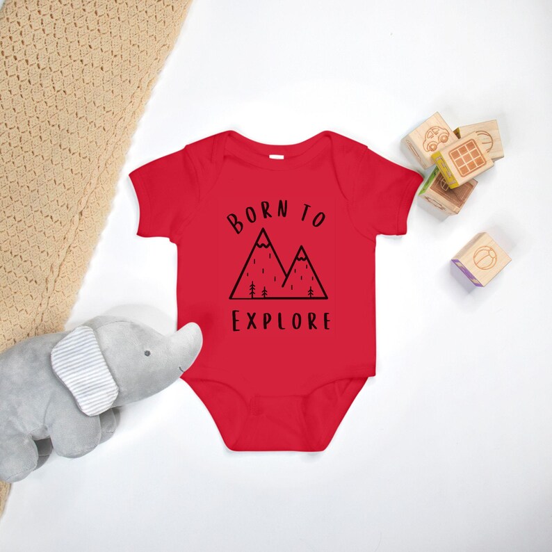 May include: Red baby onesie with a black mountain graphic and the text "Born to Explore".
