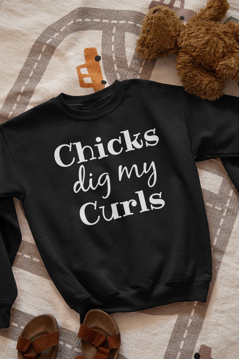 Puede incluir: Sudadera negra con texto blanco que dice "Chicks dig my curls".