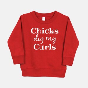 Puede incluir: Sudadera roja con texto blanco que dice "Chicks dig my Curls".