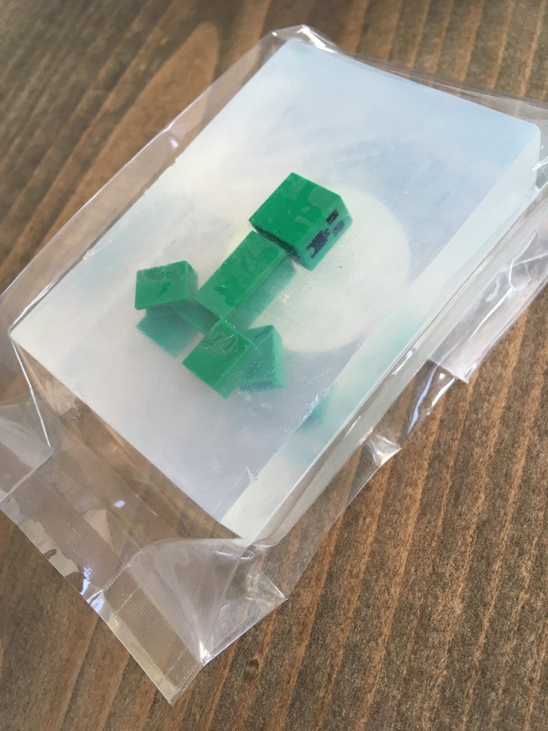 May include: A clear plastic mold with a green Minecraft Creeper character inside.