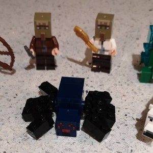 May include: A set of seven Minecraft Lego minifigures, including a skeleton with a bow and arrow, two villagers, a creeper, a spider, a sheep, and a polar bear.