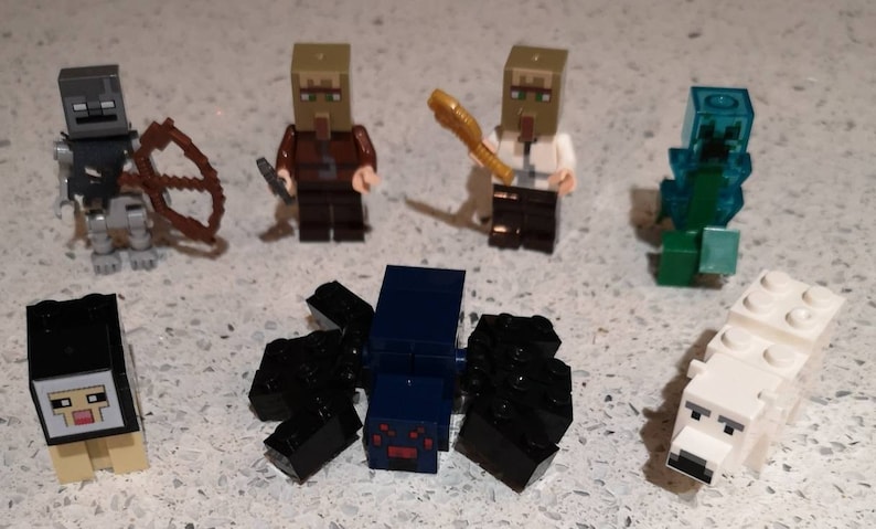 May include: A set of seven Minecraft Lego minifigures, including a skeleton with a bow and arrow, two villagers, a creeper, a spider, a sheep, and a polar bear.