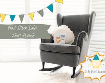 May include: A dark gray wingback rocking chair with black wooden rockers, featuring a round white textured pillow and a children's book titled The Fox Who Lost His Tail. The image includes bunting, text reading Final Stock Sale! Won't Restock!, and a graphic with text Only 14 left in stock!!