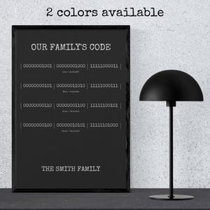 May include: A black framed wall art print titled OUR FAMILY'S CODE with white text. It displays binary sequences, names, and dates, followed by THE SMITH FAMILY at the bottom. The text 2 colors available appears at the top of the print.