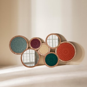 Peut inclure: Composition murale d&eacute;corative avec sept miroirs circulaires de diff&eacute;rentes tailles. Chaque miroir a un cadre en bois et un int&eacute;rieur &agrave; motifs dans des couleurs comme le turquoise, le bordeaux et l'orange. Disposition en chevauchement.