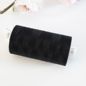 May include: A black spool of Coats & Clark thread labelled "RB10".