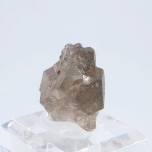 May include: A cluster of smoky quartz crystals with a light brown color. The crystals are intergrown and have a rough, natural surface.