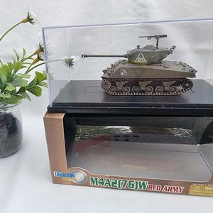 May include: A scale model of an olive green M4A2(76)W Red Army tank displayed inside a clear plastic case on a black base. The tank features a turret with the number 154, a mounted machine gun, and tracks. The packaging box is visible below.