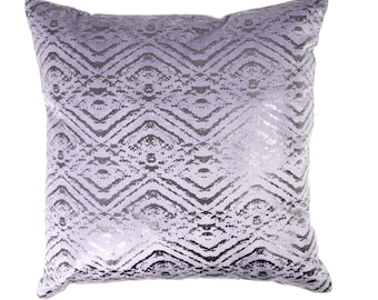 Könnte beinhalten: Ein lavendelfarbenes Kissen mit einem silbernen Chevron-Muster. Das Kissen ist weich und plüschig, und das Muster ist dezent und elegant.