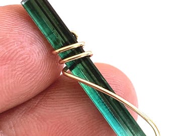 Pendentif en or 14 carats serti sous tension, orné d'un cristal de tourmaline Paraiba.