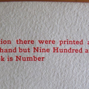 May include: Close-up of a page from a book with red text that reads "Of this edition there were printed and specially illuminated by hand but Nine Hundred and Forty copies, and this book is Number"